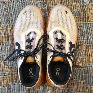 On Running White and Orange Athletic Shoes